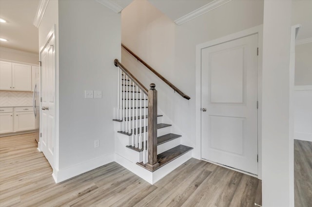 stairway featuring crown molding and wood-type flooring