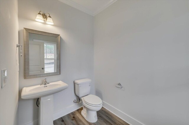 bathroom with sink, toilet, ornamental molding, and hardwood / wood-style flooring