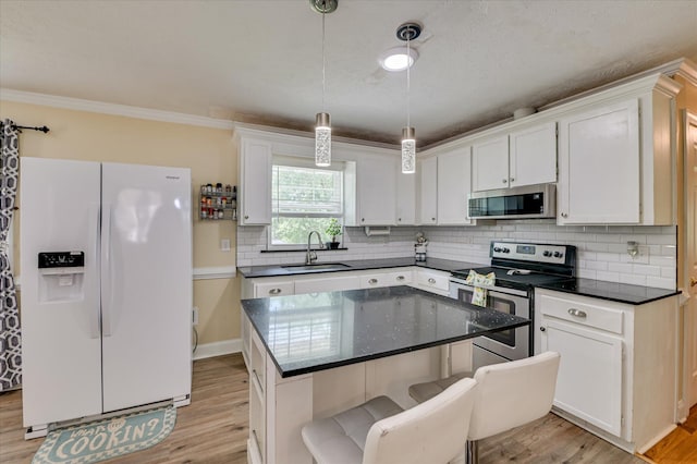 141 Whaley St, Warrenville, SC 29851 - kitchen with stainless steel appliances, light wood finished floors, white cabinets, and ornamental molding