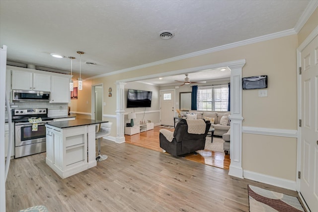 141 Whaley St, Warrenville, SC 29851 - kitchen with stainless steel appliances, decorative columns, dark countertops, ornamental molding, and open floor plan