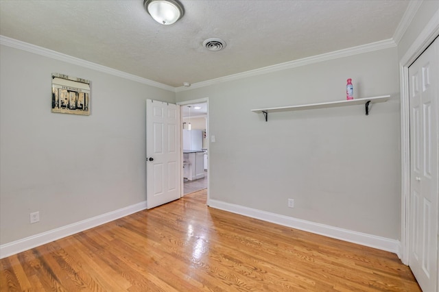 141 Whaley St, Warrenville, SC 29851 - unfurnished bedroom with crown molding, light wood-type flooring, a closet, and a textured ceiling