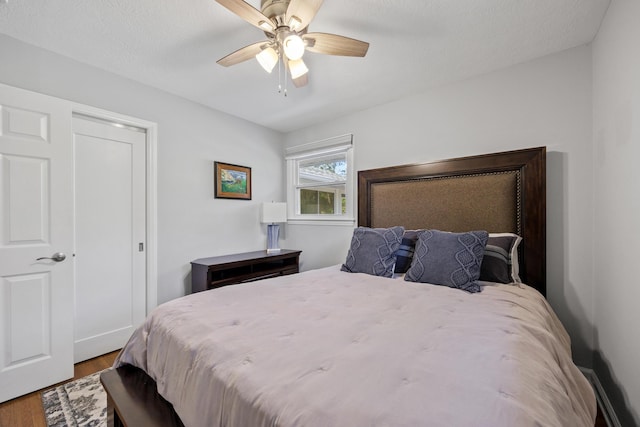 bedroom with hardwood / wood-style floors, a textured ceiling, and ceiling fan