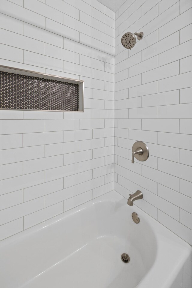 bathroom featuring tiled shower / bath