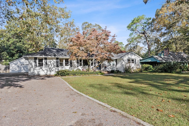 ranch-style house featuring a garage and a front lawn