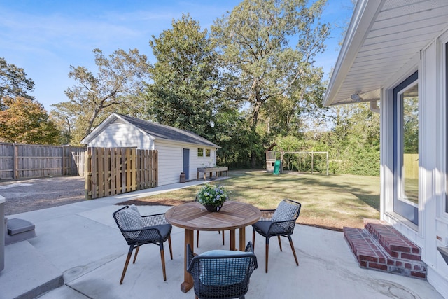 view of patio featuring an outdoor structure and a playground