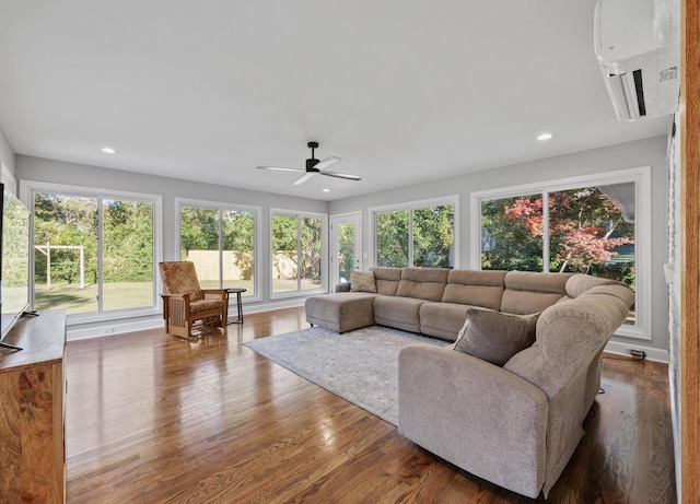 living room featuring a wall unit AC, ceiling fan, and hardwood / wood-style flooring