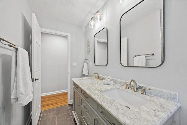 bathroom with tile patterned flooring, a textured ceiling, and vanity