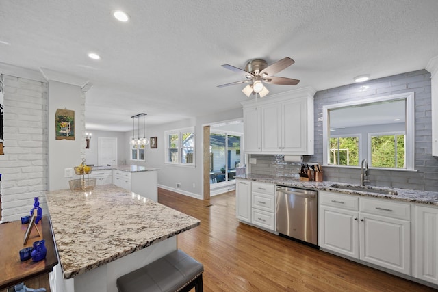 kitchen with white cabinetry, sink, a center island, tasteful backsplash, and stainless steel dishwasher