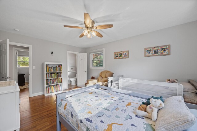 bedroom with connected bathroom, ceiling fan, and dark hardwood / wood-style flooring