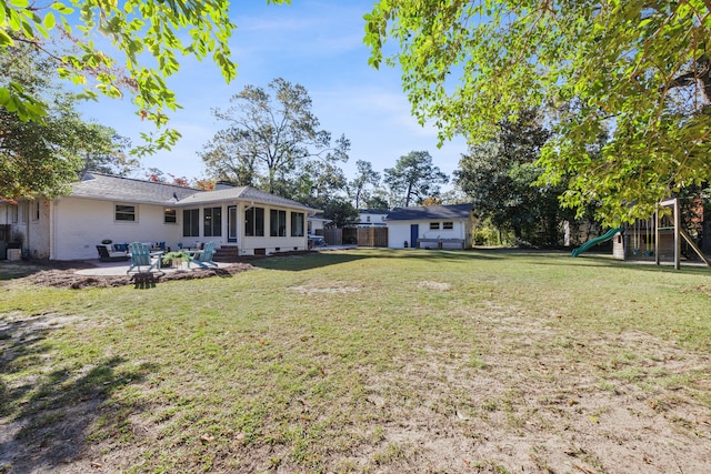 view of yard with a playground, a sunroom, and a patio