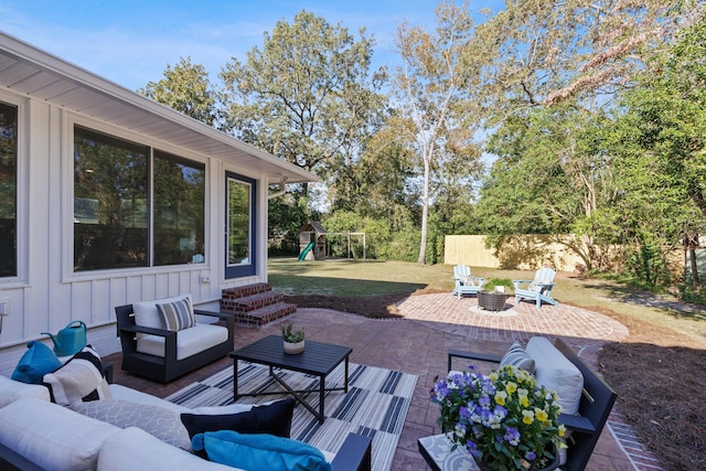 view of patio / terrace featuring a playground and an outdoor living space with a fire pit