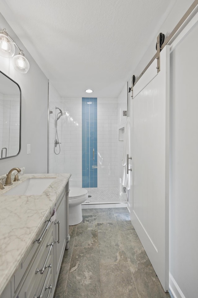 bathroom featuring a textured ceiling, vanity, toilet, and a shower with door