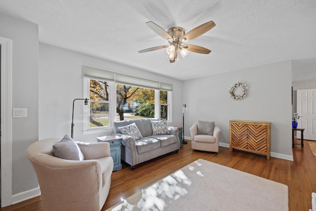 living room with a textured ceiling, ceiling fan, and dark hardwood / wood-style floors