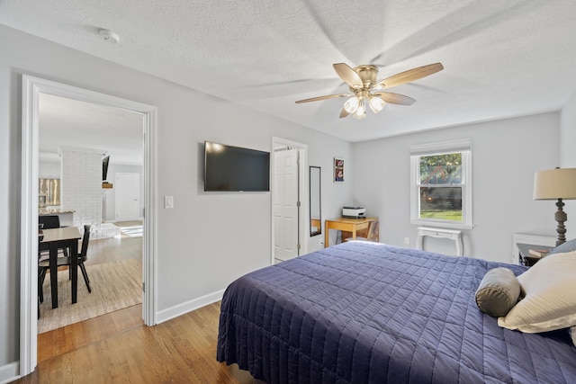 bedroom featuring a textured ceiling, light hardwood / wood-style flooring, and ceiling fan