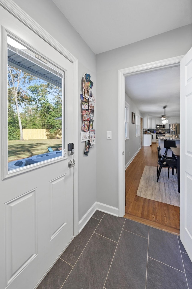 doorway to outside featuring dark tile patterned floors