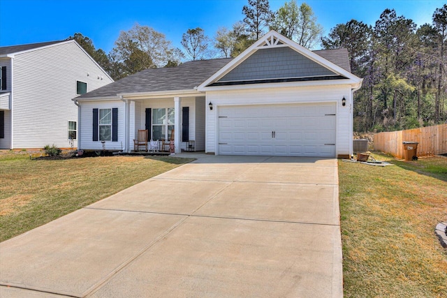 view of front of home featuring covered porch, a garage, a front lawn, and central air condition unit