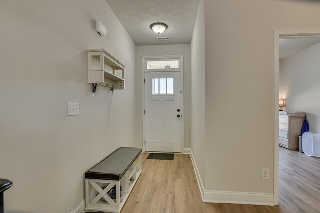 entryway featuring a textured ceiling and light wood-type flooring