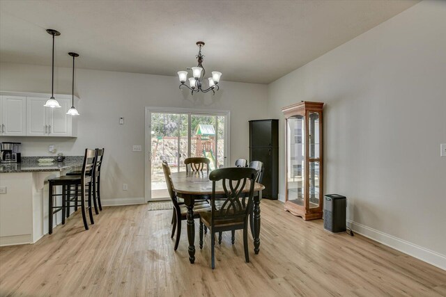 dining space with a chandelier and light hardwood / wood-style flooring