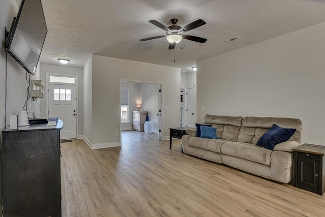 living room with ceiling fan and light hardwood / wood-style flooring