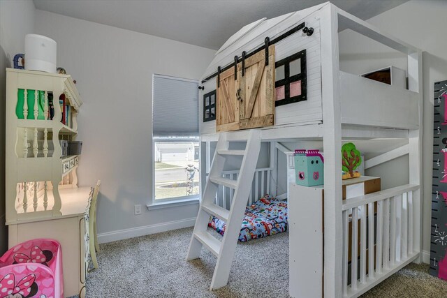 bedroom with carpet and a barn door