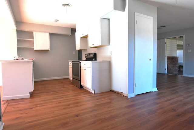 kitchen with dark hardwood / wood-style flooring, electric range, and white cabinetry