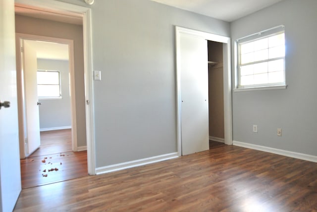 unfurnished bedroom featuring dark hardwood / wood-style flooring and a closet