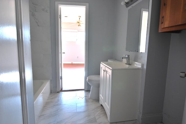 bathroom featuring vanity, toilet, ceiling fan, and a bathing tub