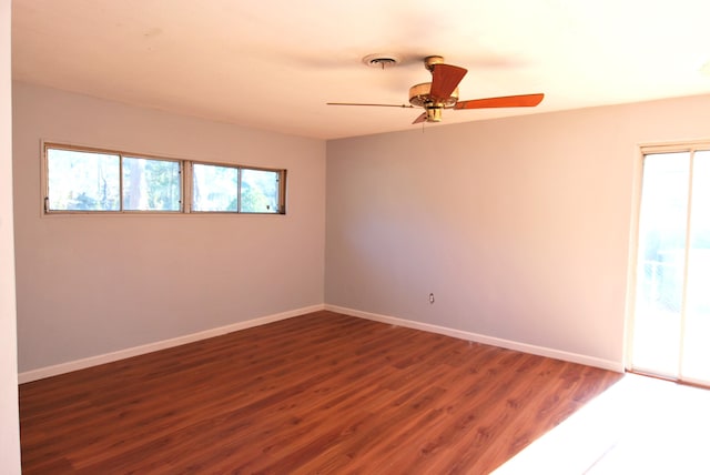 empty room with ceiling fan and dark hardwood / wood-style flooring