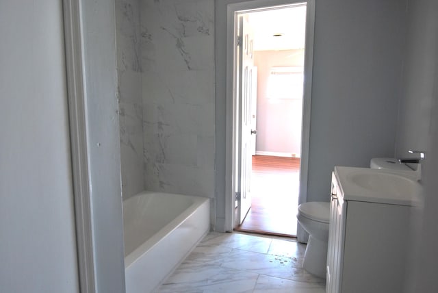 bathroom featuring vanity, a bath, and toilet