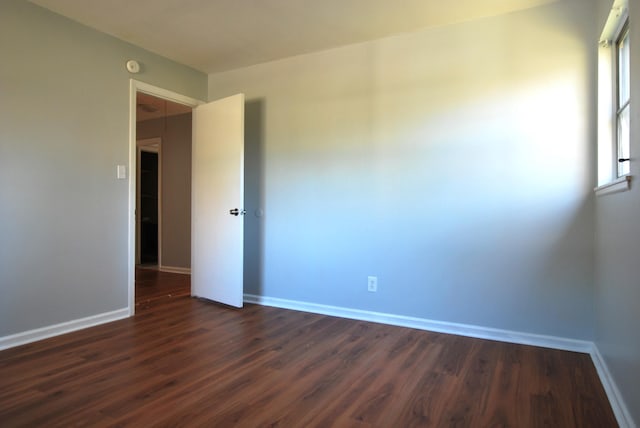 unfurnished room with dark hardwood / wood-style floors