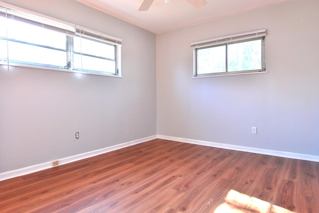 spare room with ceiling fan and dark hardwood / wood-style floors