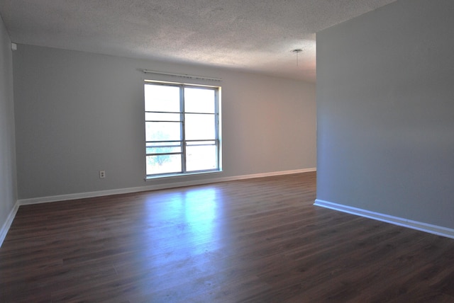 spare room with dark hardwood / wood-style flooring and a textured ceiling