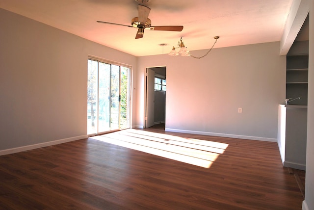 unfurnished room with dark hardwood / wood-style flooring and ceiling fan with notable chandelier