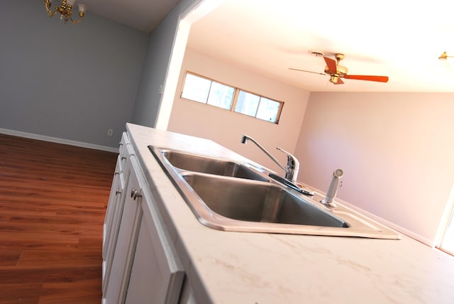 kitchen featuring dark hardwood / wood-style flooring, white cabinetry, and sink