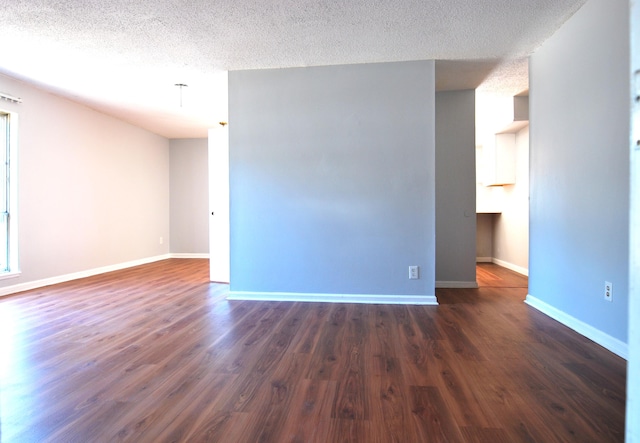 spare room featuring a textured ceiling and dark wood-type flooring