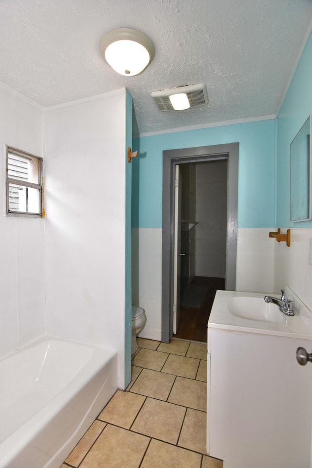 bathroom featuring tile patterned floors, crown molding, a textured ceiling, toilet, and vanity