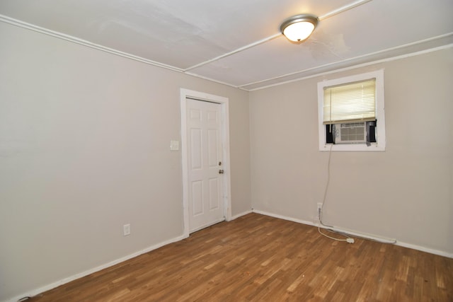 spare room featuring cooling unit and hardwood / wood-style flooring