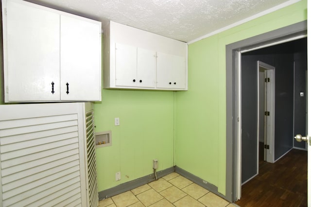 laundry room featuring cabinets, a textured ceiling, and hookup for a washing machine