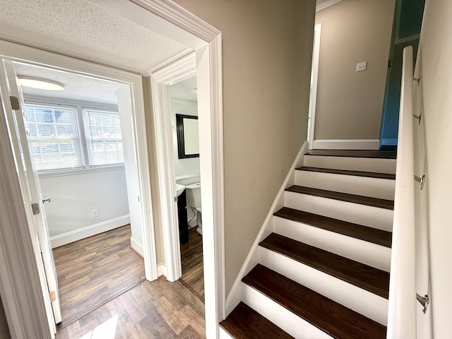 staircase with wood finished floors and baseboards