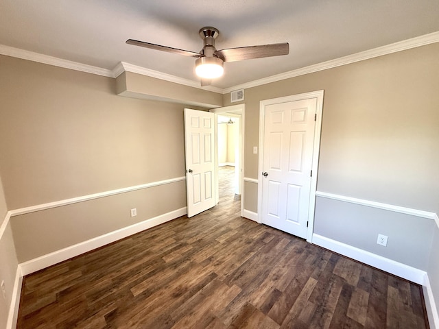 unfurnished bedroom featuring ornamental molding, dark wood-type flooring, visible vents, a ceiling fan, and baseboards