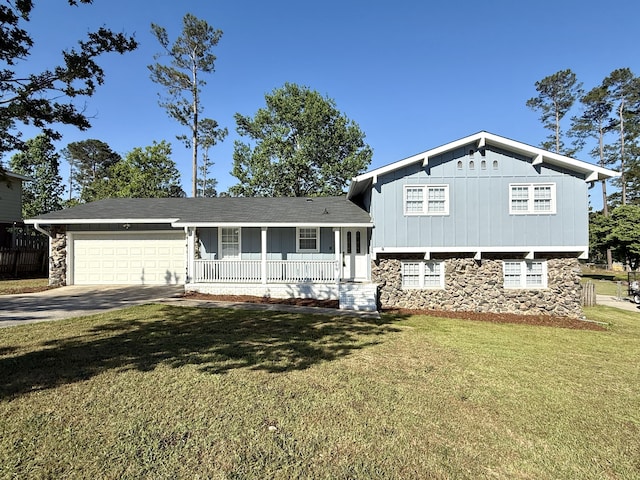 tri-level home featuring a porch, stone siding, driveway, a garage, and a front lawn