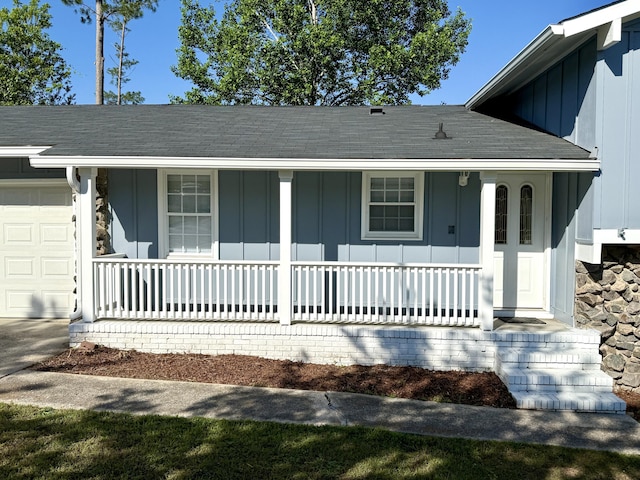 view of front of house featuring board and batten siding, a shingled roof, covered porch, and an attached garage