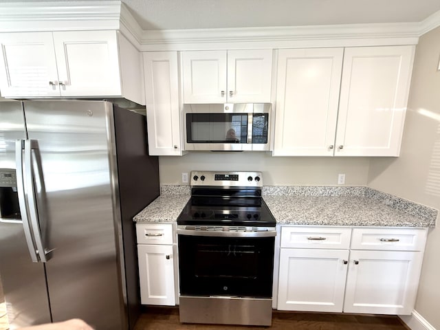kitchen featuring stainless steel appliances, light stone counters, and white cabinets