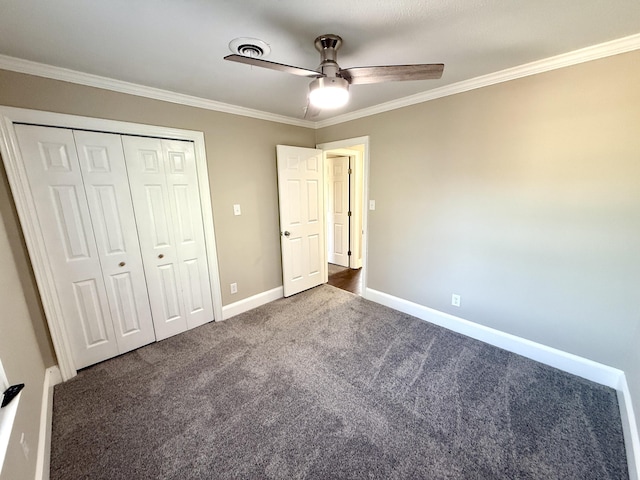 unfurnished bedroom featuring ornamental molding, baseboards, a closet, and dark carpet