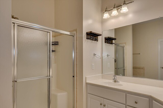 bathroom featuring vanity and a shower with shower door