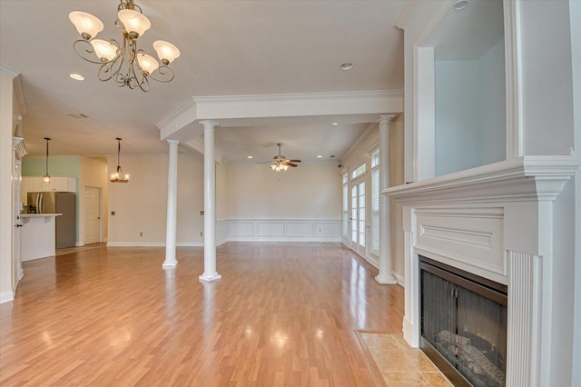 unfurnished living room featuring crown molding, light hardwood / wood-style flooring, and ceiling fan with notable chandelier