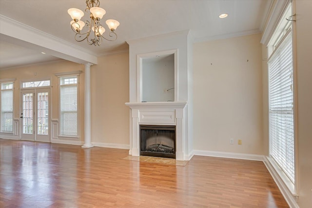 unfurnished living room featuring ornamental molding, a chandelier, and light wood-type flooring