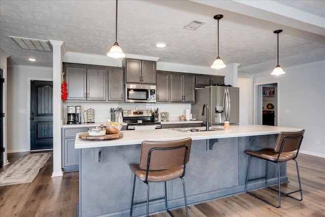 kitchen with a sink, appliances with stainless steel finishes, a large island, and visible vents