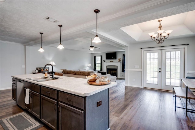 kitchen featuring dark brown cabinetry, a sink, a fireplace, light countertops, and stainless steel dishwasher