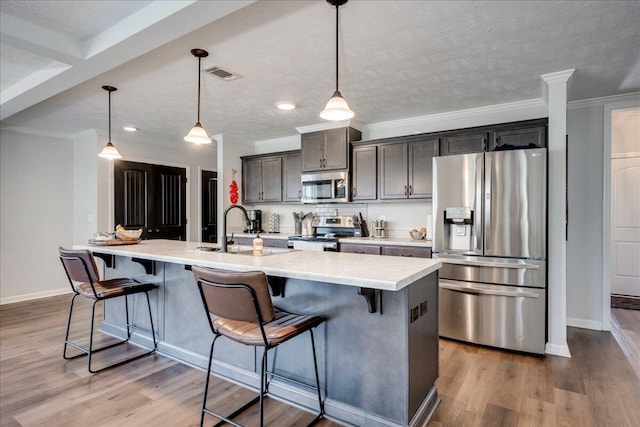kitchen with visible vents, a sink, baseboards, light countertops, and stainless steel appliances